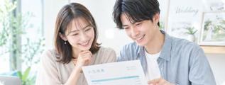 結婚式の見積書を笑顔で確認するカップル