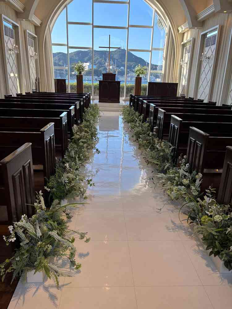 自然を感じさせるチャペル全体の写真。窓ガラスから見える青空と装花がマッチして綺麗でした。