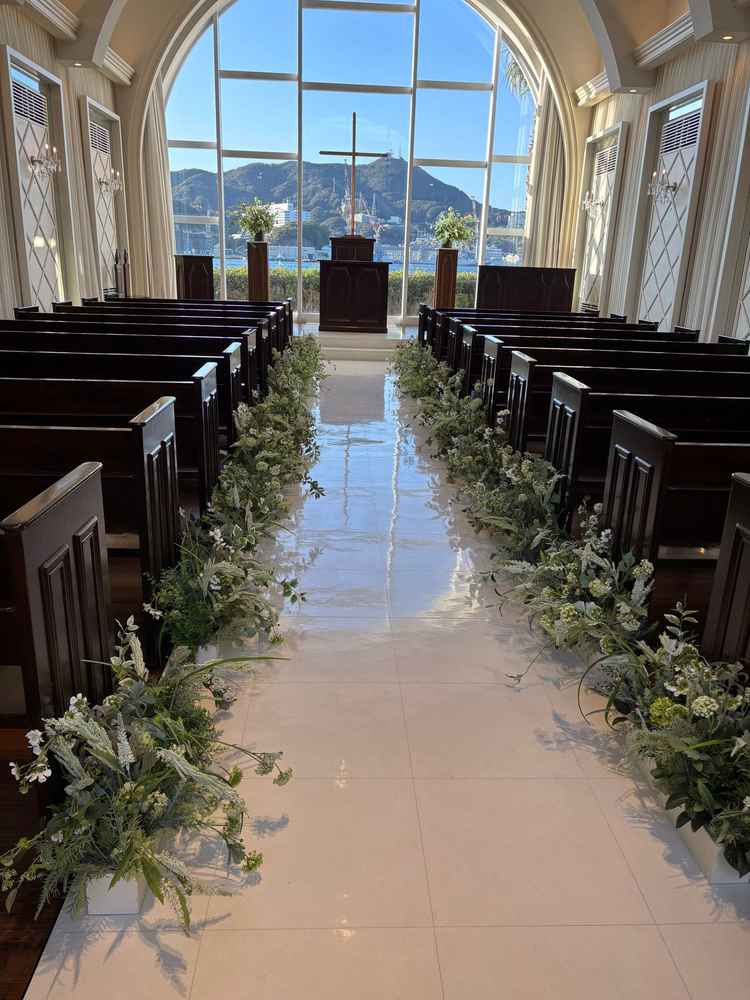 自然を感じさせるチャペル全体の写真。窓ガラスから見える青空と装花がマッチして綺麗でした。