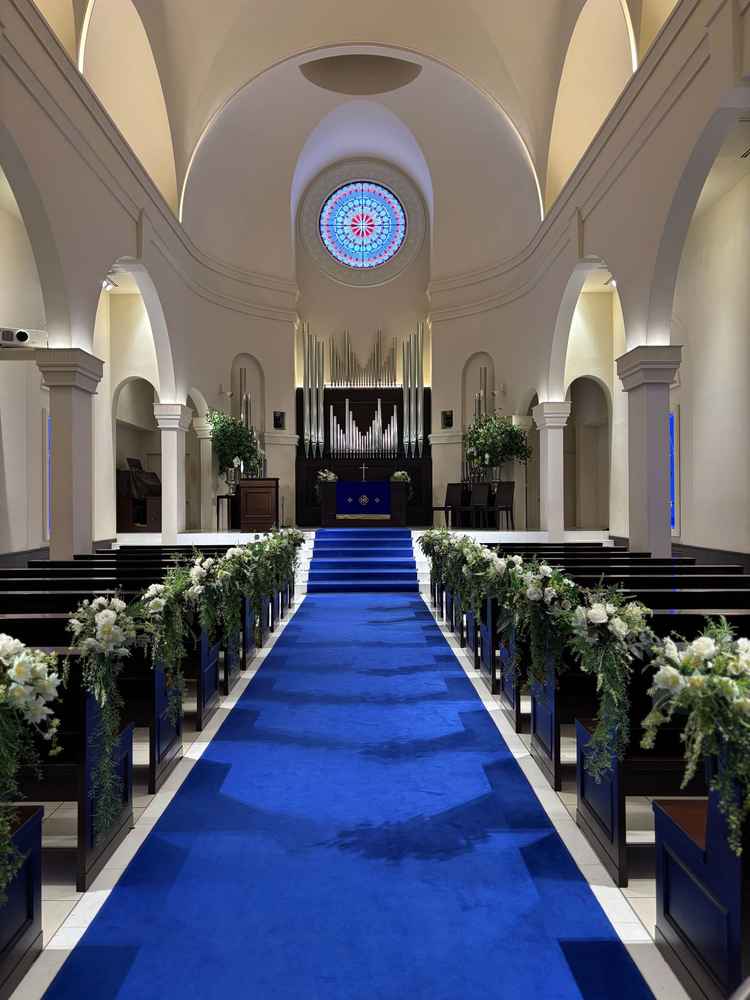 青いバージンロードが印象的でした。シンプルで品のあるステンドグラスや装飾で素敵でした。