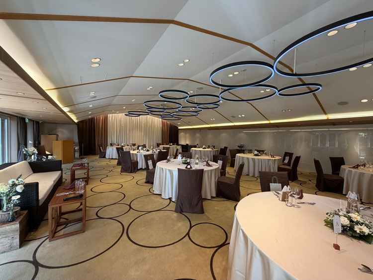 落ち着いた色味で統一された上品な披露宴会場で、天井の円形照明が印象的。