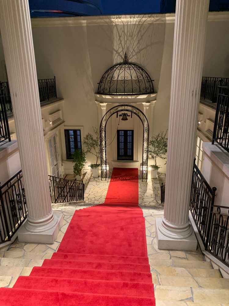 大階段上からの景色。赤い絨毯がひいてあり足元もふかふか。奥に鐘がある。