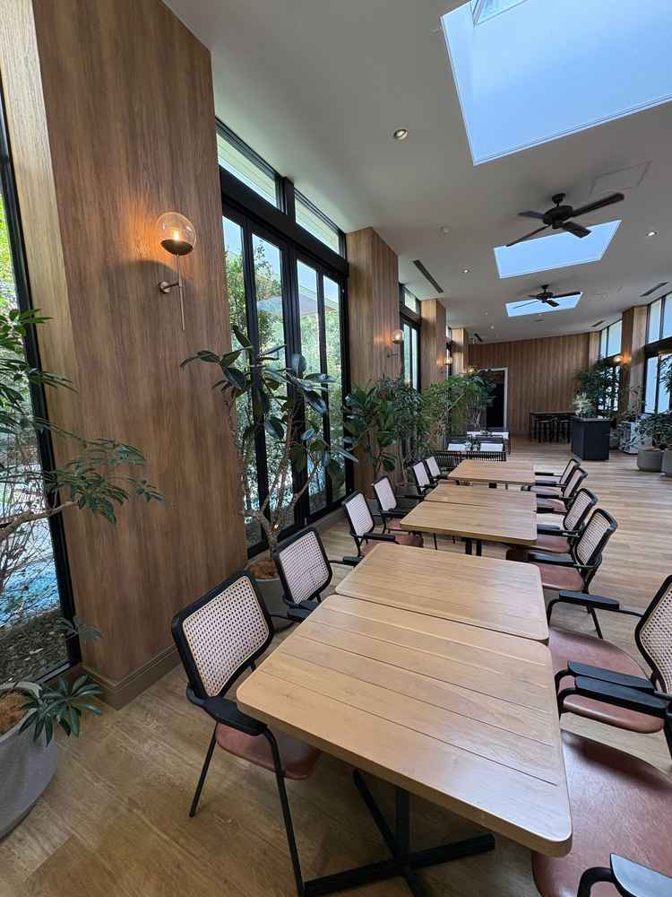 ゲスト待合室のカフェスペース。おしゃれ！　木目調の家具とオレンジ系の照明がマッチングでカフェみたい！