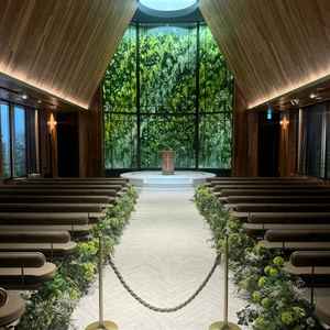 挙式会場。木のぬくもりと緑のコントラストが美しく、柔らかな光に包まれた空間で神聖さを感じました。