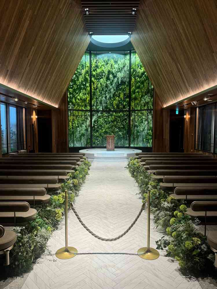 挙式会場。木のぬくもりと緑のコントラストが美しく、柔らかな光に包まれた空間で神聖さを感じました。
