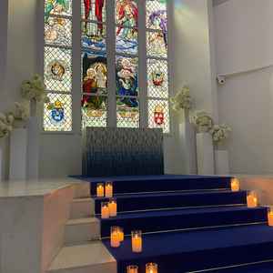 本物のステンドグラスと青い絨毯が印象的な白が基調の挙式会場。