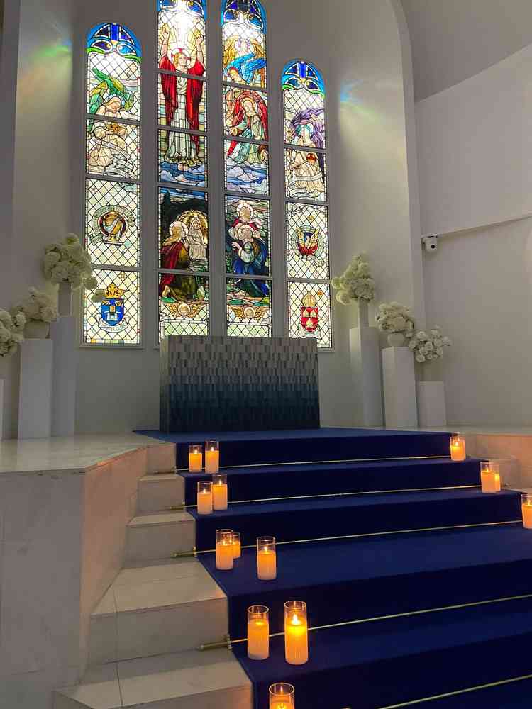 本物のステンドグラスと青い絨毯が印象的な白が基調の挙式会場。