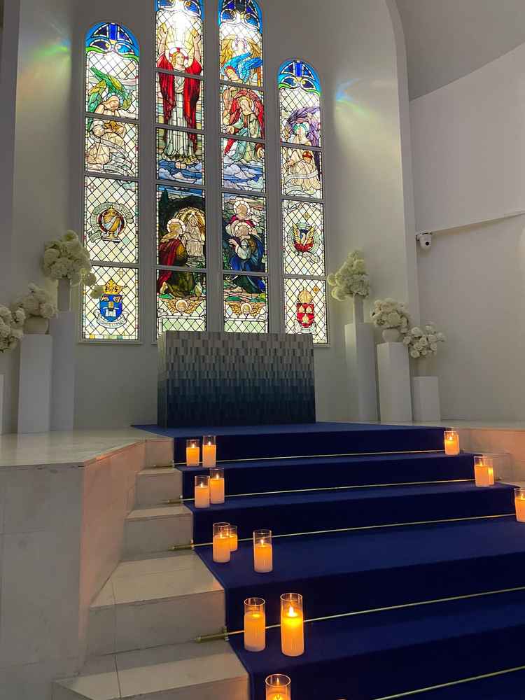 本物のステンドグラスと青い絨毯が印象的な白が基調の挙式会場。