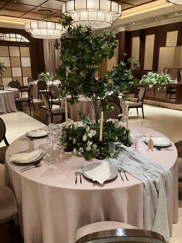 装花とテーブルウェア。グリーンが主体の装花、落ち着いた雰囲気のコーディネートが部屋に似合っていた。