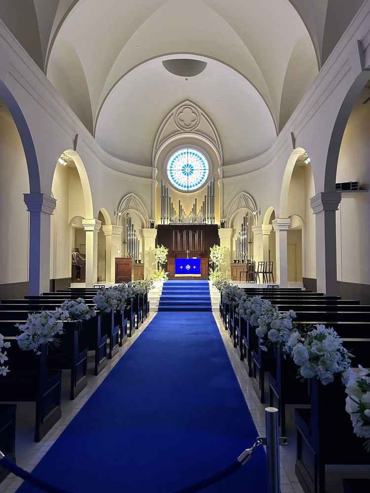 挙式会場の写真です。白色の壁とブルーのカーペットのバージンロードのコントラストが美しかったです。