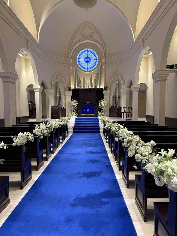 チャペル。天井が高く音が綺麗に響く。青いカーペットがウエディングドレスの白とのコントラストで映える