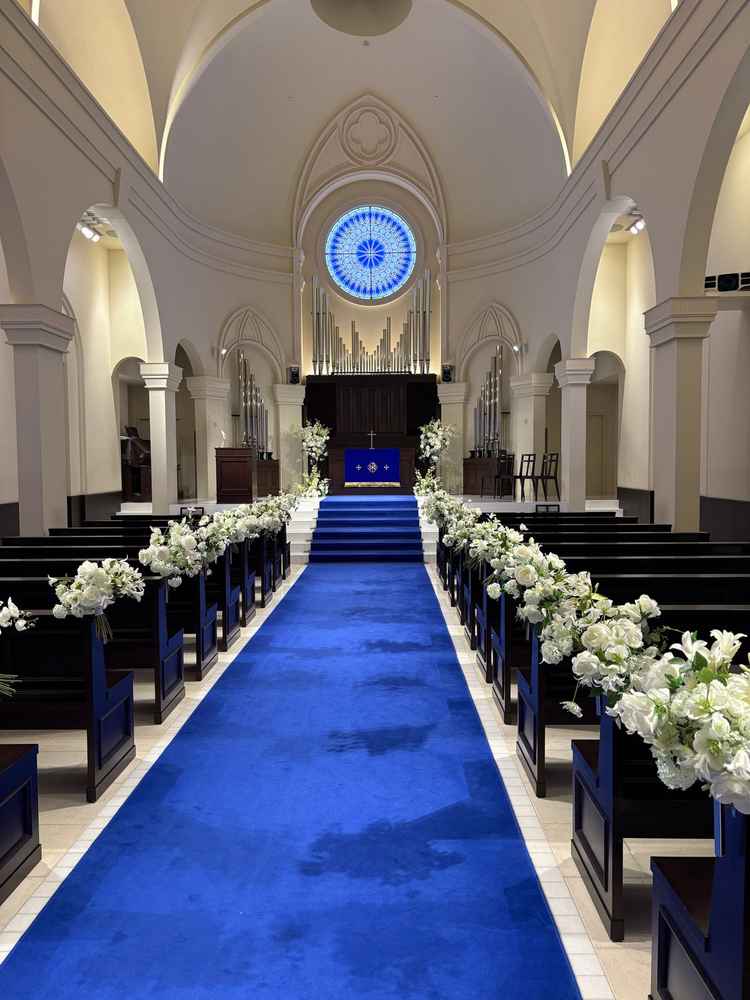 チャペル。天井が高く音が綺麗に響く。青いカーペットがウエディングドレスの白とのコントラストで映える
