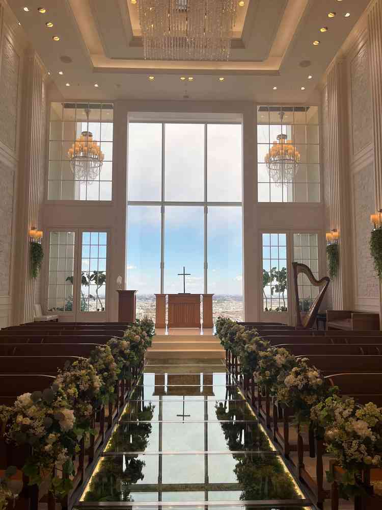 青空と緑、真っ白な壁のコントラストが映えるチャペル。バージンロードは緑が敷き詰められて、ウエディング