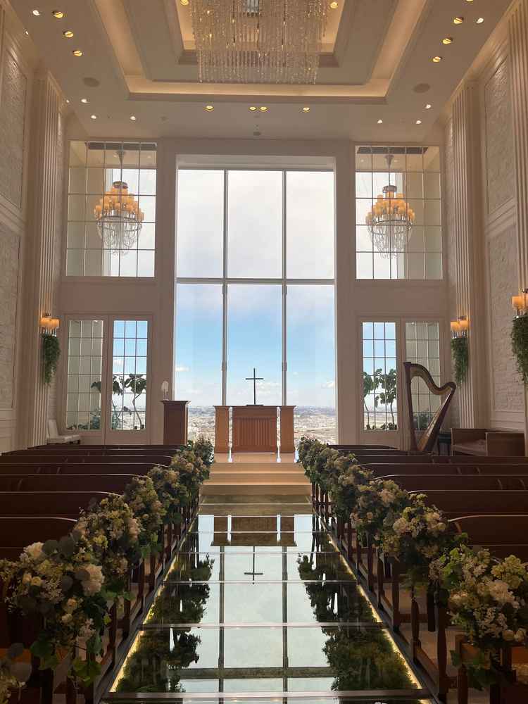 青空と緑、真っ白な壁のコントラストが映えるチャペル。バージンロードは緑が敷き詰められて、ウエディング