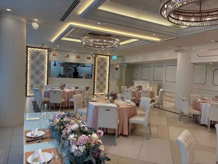 白基調の披露宴会場。ピンクと白でラブリーにもできるし白と青でクールにも変えられるというのがよかった