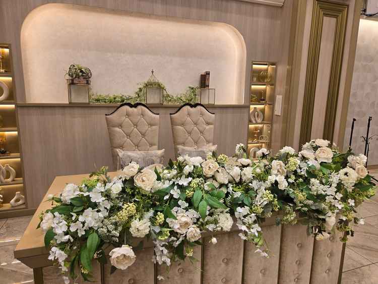 時計台を貴重とした披露宴会場の高砂。お花によって一気に華やかさが増すように感じました。