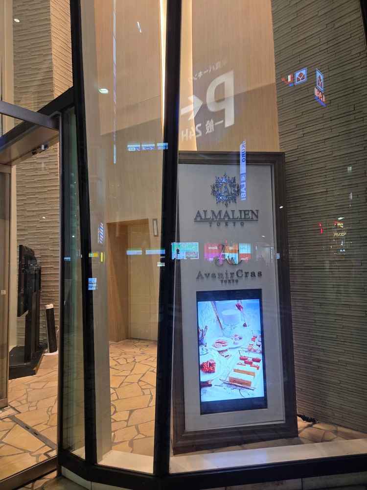 エントランスの看板と、入り口のエレベーター　担当者が出迎えてくれた