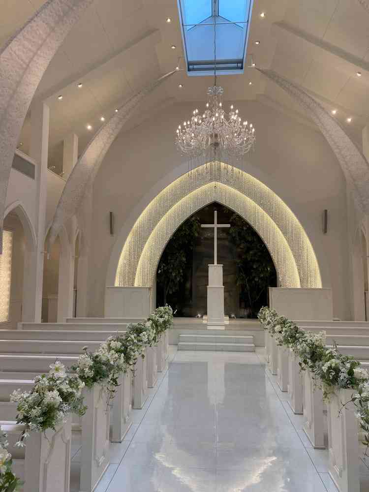 白を基調とした挙式会場。上に窓がある事で自然光が入りヴァージンロードが綺麗に輝くとのことでした。