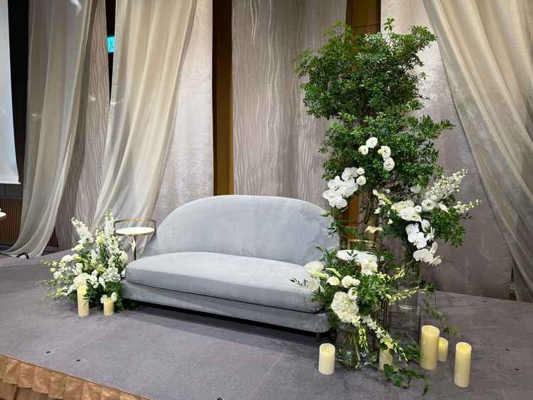 披露宴会場の高砂の写真。グリーン×ホワイト×グレーと理想な色合いの会場を見れたことはとても良かっ