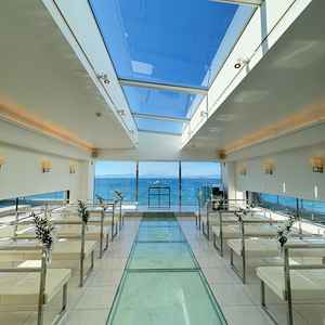 自然光が最大限に入るチャペル。バージンロードがガラス面の下に砂浜と貝殻が散りばめられている。