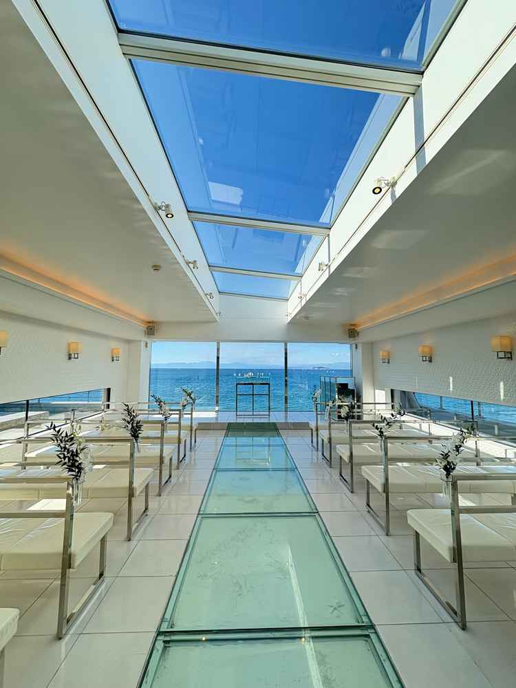 自然光が最大限に入るチャペル。バージンロードがガラス面の下に砂浜と貝殻が散りばめられている。