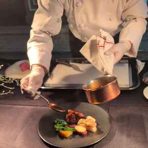 シェフが調理の仕上げを目の前でパフォーマンスしてくれる様子です。