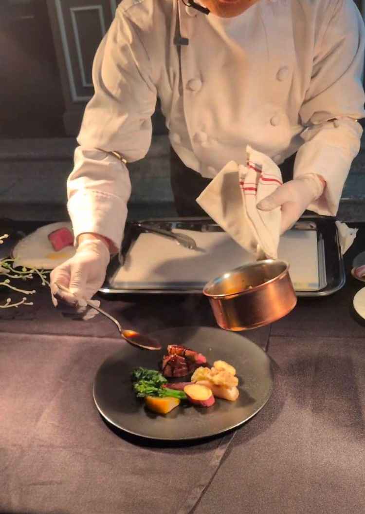 シェフが調理の仕上げを目の前でパフォーマンスしてくれる様子です。