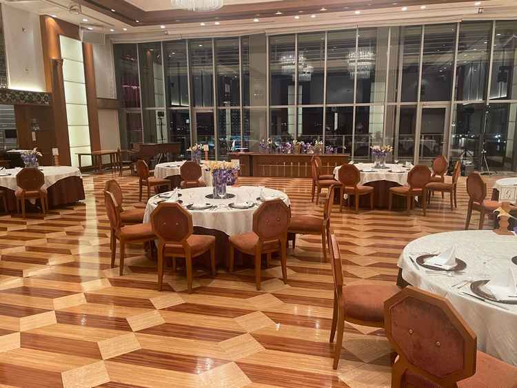 夜景が広がる披露宴会場、大きな窓の向こうに広がる夜景と、上品にセッティングされた円卓がとても魅力的