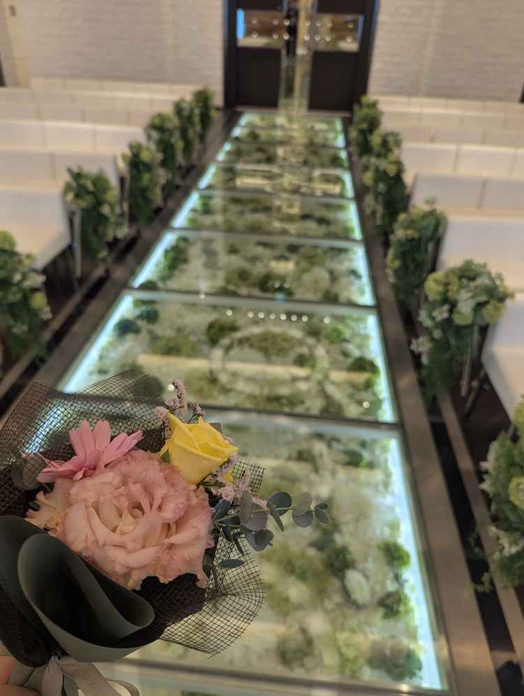 花をバージンロードにあしらったチャペル、プチブーケをフラワーアーティストさんにもらった。