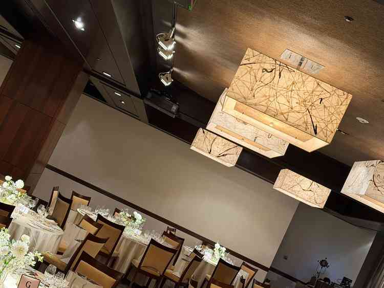 和紙の照明がとてもオシャレな雰囲気の披露宴会場。カーテンを開くと日本庭園が現れる。