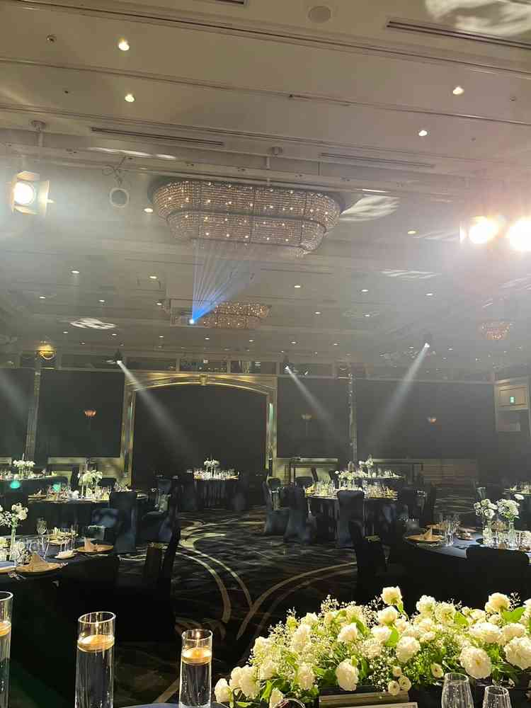 披露宴会場はロイヤルブルーを基調としたテーブル・イスとピンクゴールドのシャンデリア、各種照明が華やか