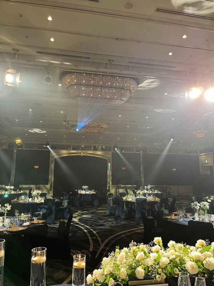 披露宴会場はロイヤルブルーを基調としたテーブル・イスとピンクゴールドのシャンデリア、各種照明が華やか