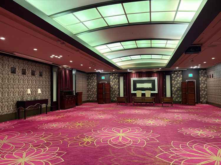 披露宴会場。テーブルのセッティングはなかったが、赤い絨毯でクラシカルな印象。