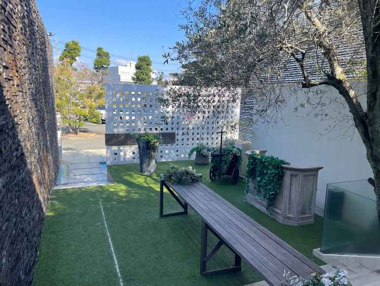 駐車場から入り口へと続く緑が多いエントランスガーデン