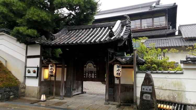 菊水楼の暖簾をくぐって入る入口には右側に菊水楼の石碑、左側に左奥にある鰻のお店の写真が飾られています