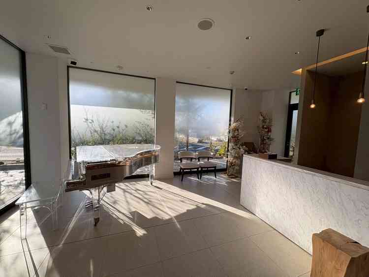 来賓の受付とピアノの写真です。リニューアルされたので会場全体が非常に綺麗でした。