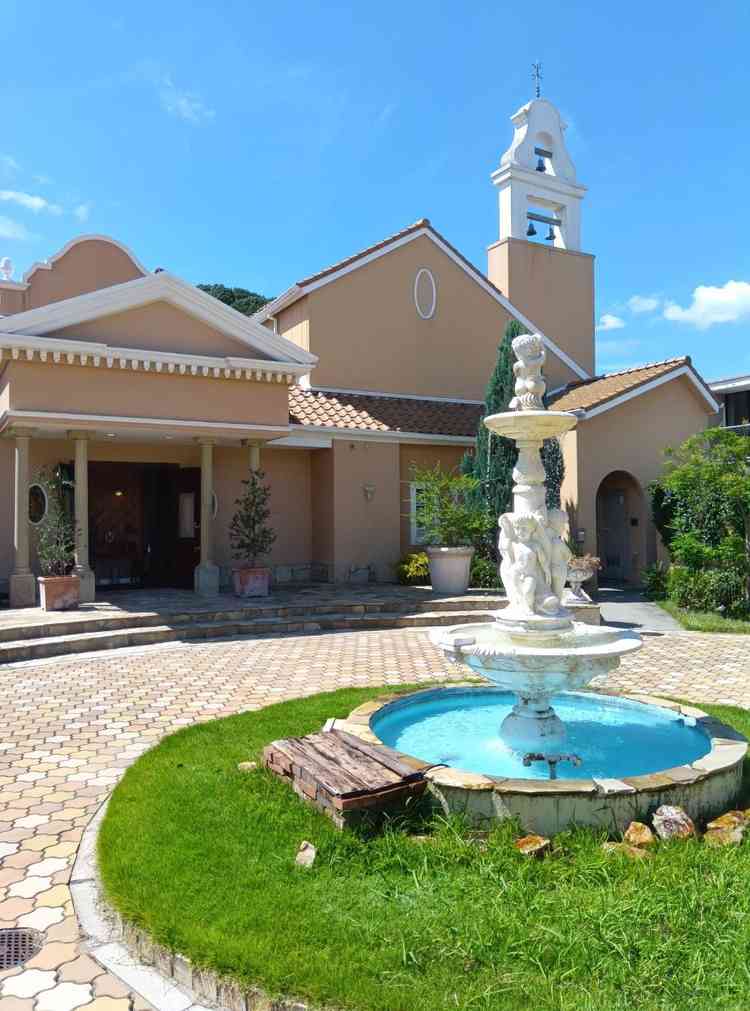 エントランスに広がるのは、南欧風の優雅な外観が印象的な建物と、愛らしい天使の像が飾られた白い噴水。