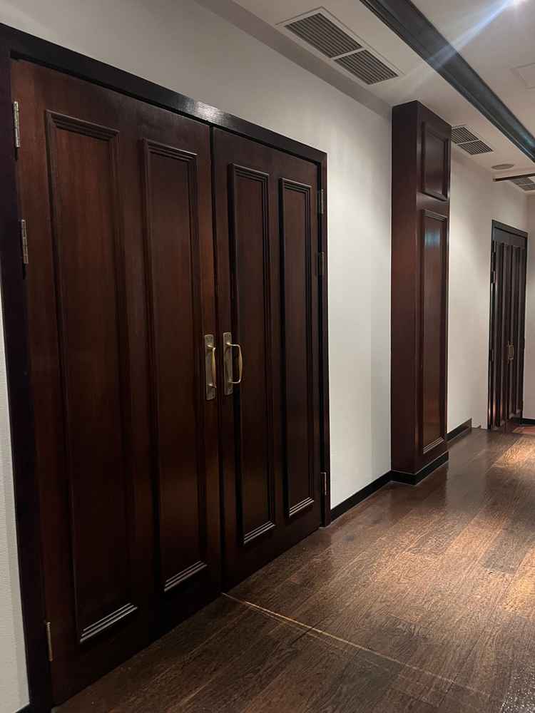 披露宴会場の外の様子。漆喰の壁が話の雰囲気を出しつつ焦茶色の扉や柱がアンティークで落ち着いた雰囲気。