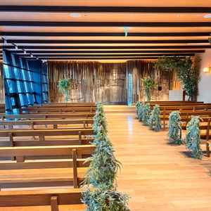 木目調と緑が調和したチャペル。大きな窓から自然光が入り、正面は名古屋城の石垣をモチーフにした石の壁。