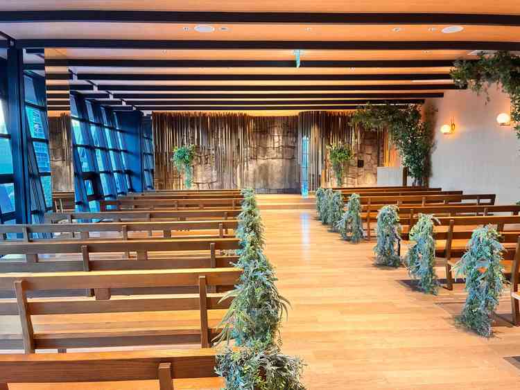 木目調と緑が調和したチャペル。大きな窓から自然光が入り、正面は名古屋城の石垣をモチーフにした石の壁。