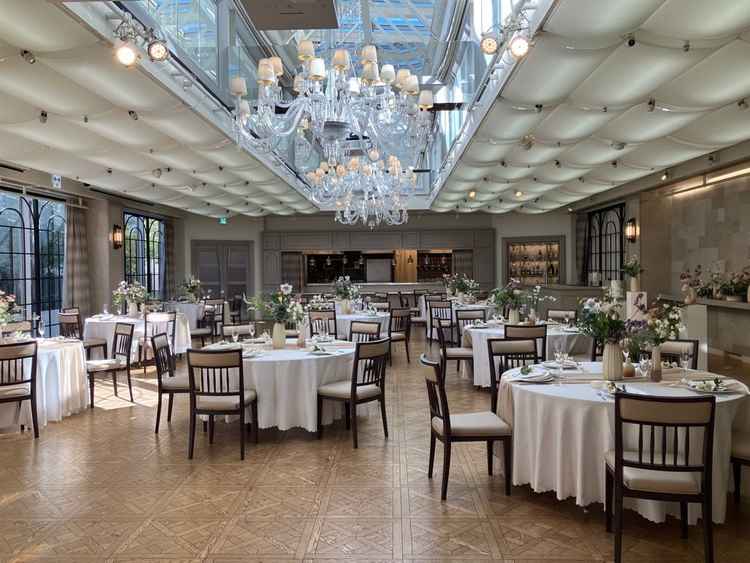 披露宴会場。天井部分がガラス張りで非常に明るい雰囲気。オープンキッチンがあって楽しい時間を過ごせそう