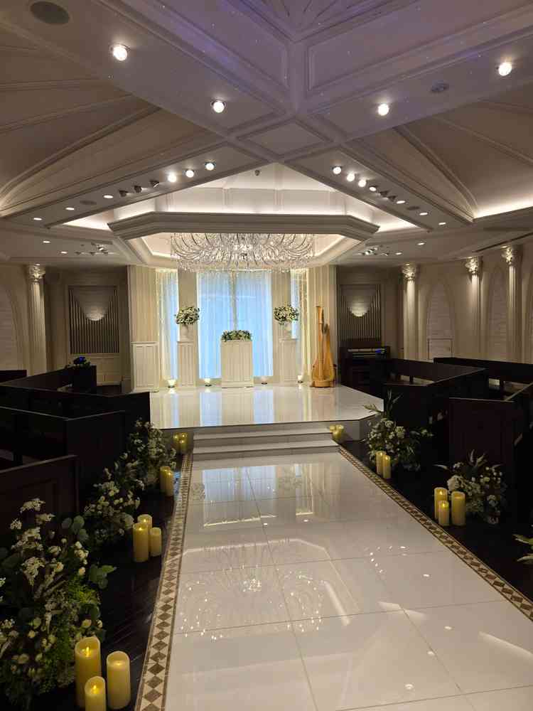 白いシンプルなチャペルは、ゲストの椅子が中央に向かって斜めになっていた。