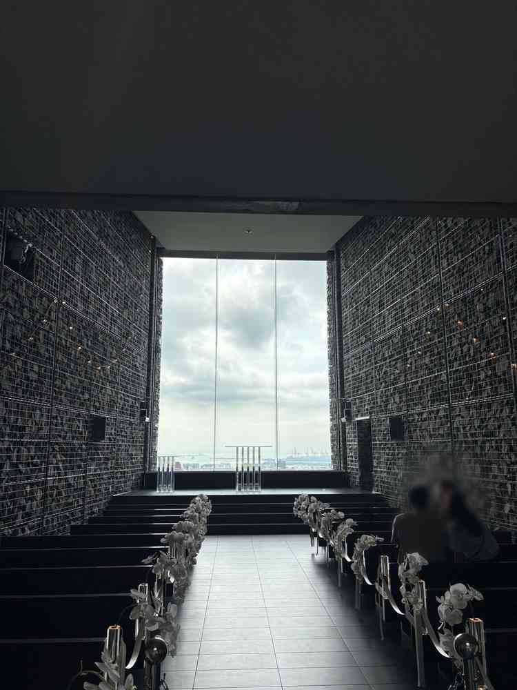 挙式会場のチャペルの正面写真です。左右石造りで囲まれており、天井も高く、正面は空一面広がっています。