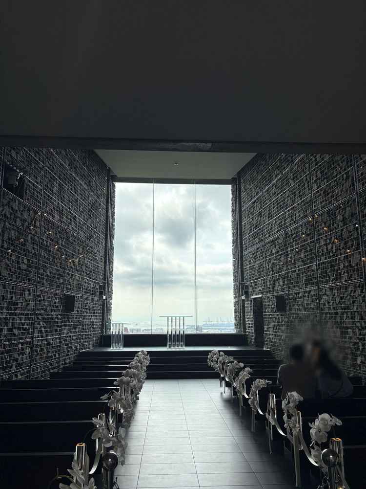 挙式会場のチャペルの正面写真です。左右石造りで囲まれており、天井も高く、正面は空一面広がっています。