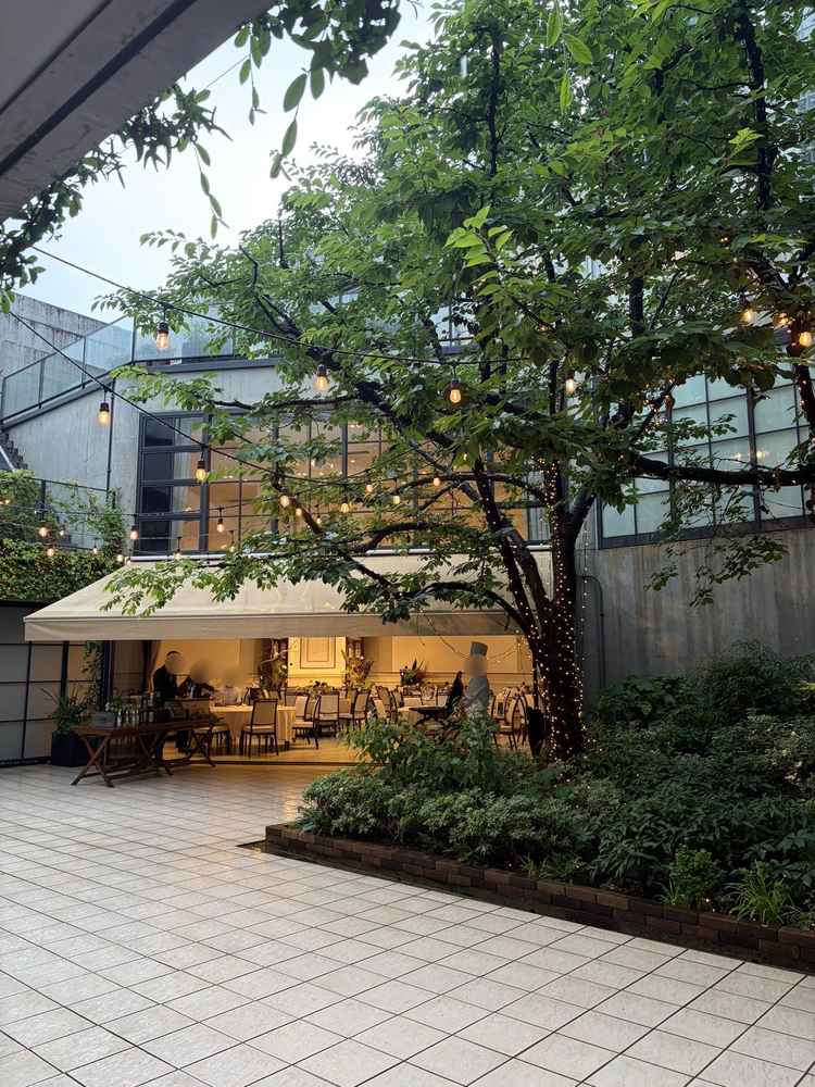 1F披露宴会場＋テラス。雨の場合は軒先に幌が出る。緑豊か。