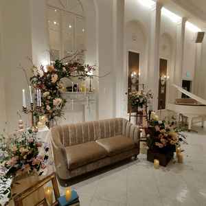 披露宴会場の新郎新婦が座るソファーと装花。披露宴会場全体は白い壁で、装花がとてもキレイに見えます。