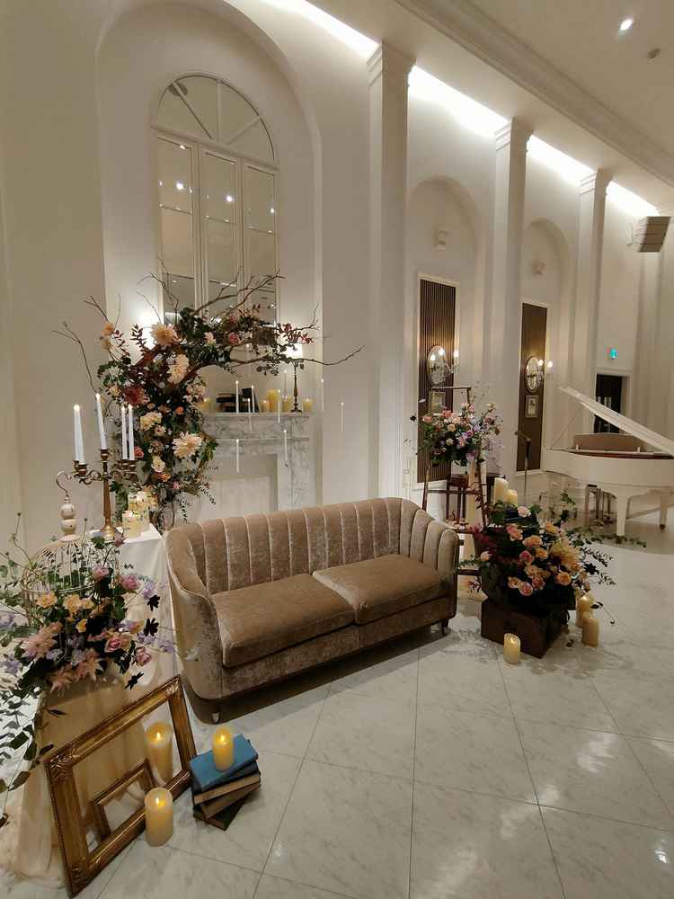 披露宴会場の新郎新婦が座るソファーと装花。披露宴会場全体は白い壁で、装花がとてもキレイに見えます。