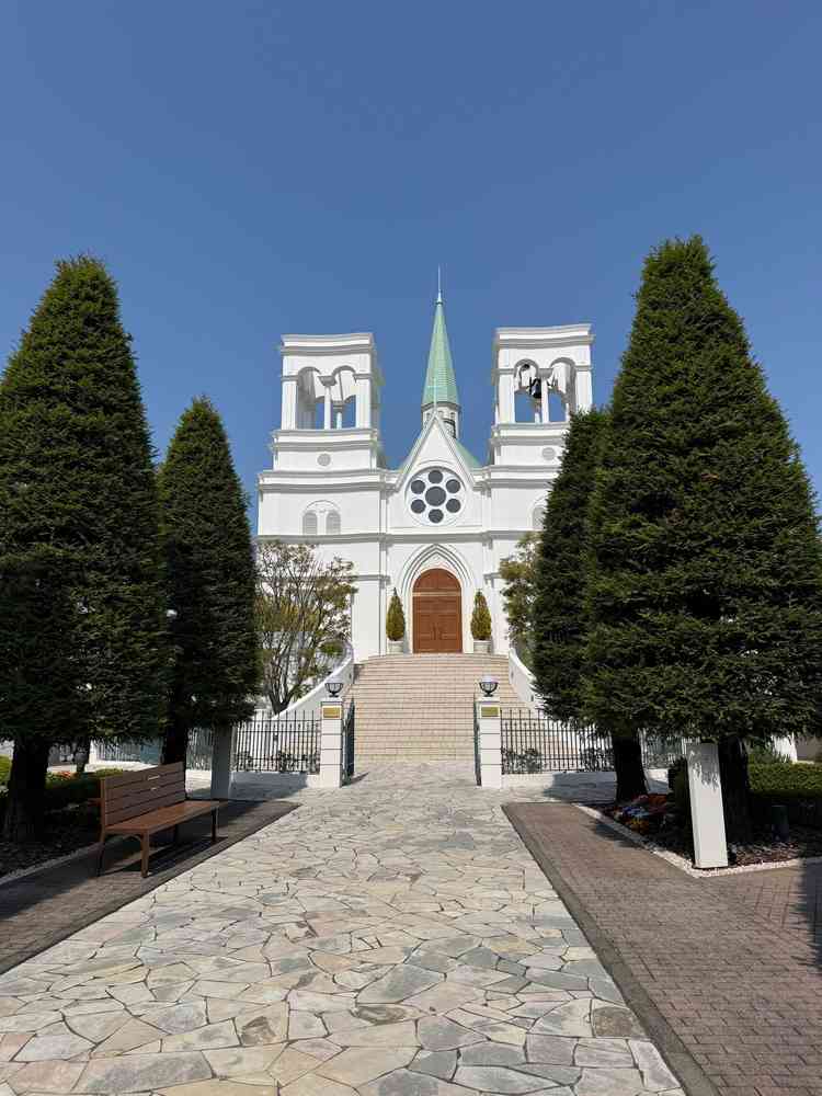 敷地に入ってすぐに見える教会の外観。空の青色と木の緑が相まって綺麗。