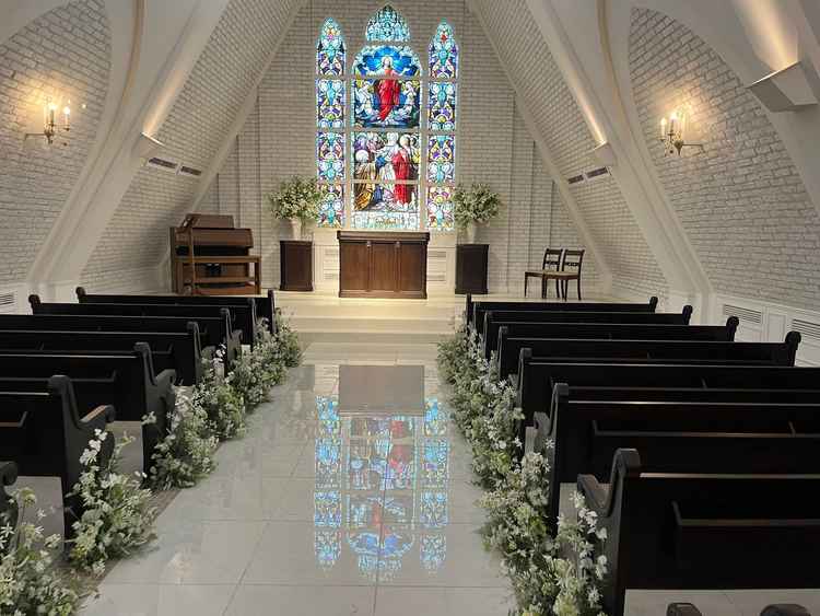 白を基調としたチャペルでステンドグラスが床に反射しロマンチック