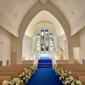 青いバージンロードが印象的でステンドグラスは唯一無二の印象。天井が高く、ムービーを流すのにも映える。